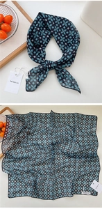 Detail view of cotton linen square scarf with teal floral pattern and white brand tag