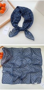 Detail of dark blue linen square scarf with white floral print and tied styling