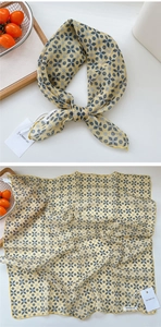 Close-up of mustard yellow cotton linen scarf with geometric floral print and knot detail