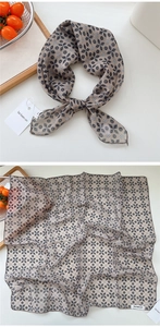 Detailed flat lay of beige and black floral cotton linen scarf showing texture and pattern