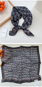 Close-up of black cotton linen scarf with paisley pattern and brand label detail
