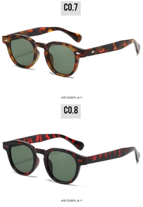 Détail de lunettes de soleil ovales rétro avec rivets en écaille de tortue et rouge-noir