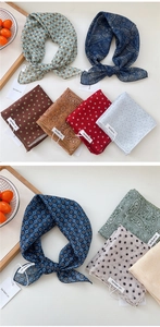 Flat lay detail of assorted polka dot and paisley pattern cotton linen scarves in various colors