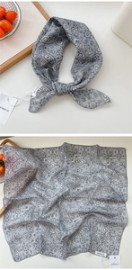 Macro view of grey paisley cotton-linen scarf with elegant knotting and soft texture