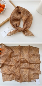 Detail of dark brown paisley square scarf with silk texture and decorative knot style