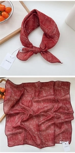Detail of square paisley scarf in dark red featuring a tied knot and flat layout view