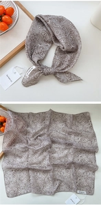 Detailed macro view of Paisley cotton linen scarf with elegant rolled hem and brand tag