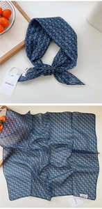 Detailed close-up of dark blue polka dot silk scarf showing texture and pattern
