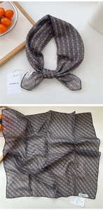 Detail view showing a retro geometric floral silk square scarf in brown and deep blue colors