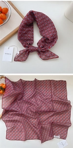Close-up of red geometric polka dot silk scarf with delicate hem and semi-sheer texture