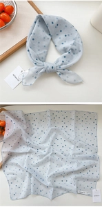 Detail of light blue polka dot scarf showing lightweight texture and fine edge stitching