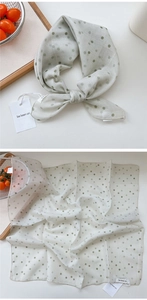 Detail of cream polka dot scarf with cotton-linen texture and vintage green dots
