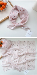 Detailed view of light pink polka dot silk scarf with cotton-linen texture and brand tags