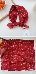 Detail of red polka dot silk scarf showing folded texture and premium washing labels