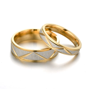 Primer plano de anillos de pareja de acero de titanio con patrones geométricos y acabado cepillado