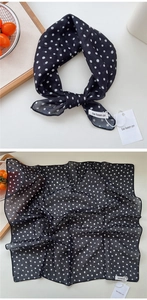 Detailed macro view of black and white polka dot silk scarf texture and elegant drape