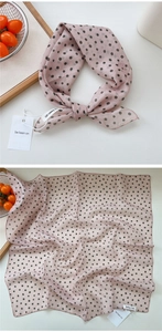 Detail of pink polka dot silk scarf featuring delicate hem and elegant texture