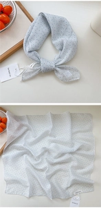 Detailed flat lay of blue polka dot square scarf with cotton linen texture and tags