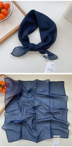 Close-up of navy blue polka dot cotton-linen scarf showing fabric texture and edge details