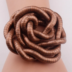 Detailed view of flexible snake-shaped necklace with bronze finish and intricate weave