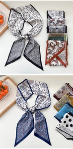 Detailed view of various paisley and geometric pattern long silk neckerchiefs and ribbons
