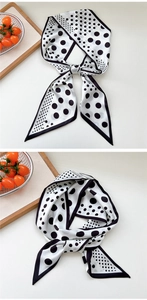 Detailed view of white narrow silk scarf with black polka dots and fine edge stitching