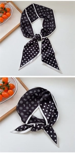 Macro detail of paisley and polka dot skinny scarves with contrast piping on wood tray