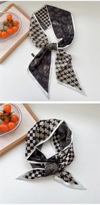 Detail of a French vintage silk scarf with paisley and houndstooth patterns on a white table