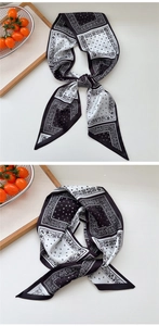 Close-up of black and white paisley silk twilly scarf with elegant polka dot patterns