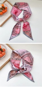 Close-up of pink and grey paisley pattern long silk scarf with elegant knotting detail