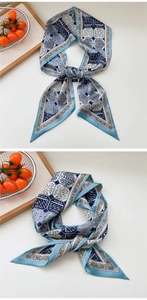 Detail of silk-like blue and white long scarf with geometric patterns and tree motifs