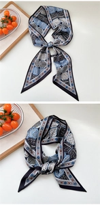 Detailed view of navy blue twilly scarf with geometric honeycomb pattern on a tray