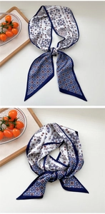 Detail of narrow paisley silk scarf with blue and white patterns and refined edges