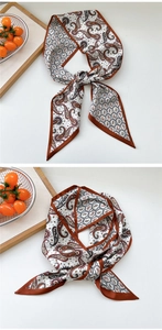 Detail of long paisley silk scarf with vintage pattern and caramel border finish