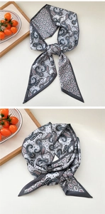 Close-up of paisley silk scarf texture with detailed border and grey geometric patterns