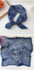 Close-up of navy blue silk scarf with white paisley pattern and floral details