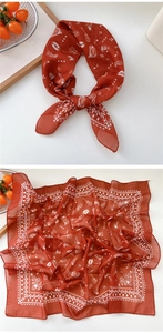 Detail of red silk scarf with musical instruments print like guitars and records