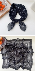 Detail view of black square scarf with white music notes and instruments print