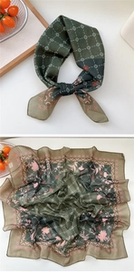 Detailed close-up of dark green floral silk scarf with pink flowers and geometric patterns