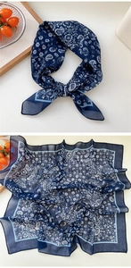 Detail of navy blue paisley silk square scarf showing intricate floral patterns and soft texture