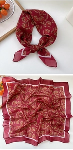 Detailed macro view showing the red floral silk scarf texture and elegant pattern