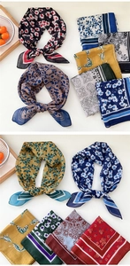 Macro detail of various floral silk scarves showing high-quality fabric texture and prints