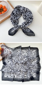 Detail view of square floral scarf with black and white patterns and elegant border