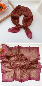 Detail of vintage floral square scarf with elegant red and brown patterns on silk texture