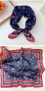 Detailed pattern view of the navy blue floral silk scarf with elegant geometric red borders