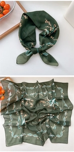 Detailed macro view of dark green floral silk scarf with fine rolled edges and leaf patterns