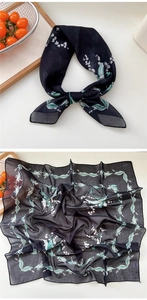 Detail of floral silk scarf showing delicate lily of the valley print and black rolled edges