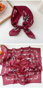 Detail of burgundy floral silk scarf featuring lily of the valley patterns and smooth edges