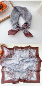 Detailed close-up of a floral paisley pattern scarf in light blue and burgundy