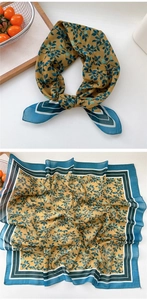Detail of floral silk scarf in mustard yellow with blue leaf patterns and geometric border